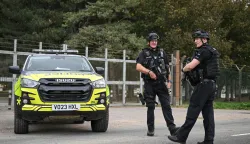 TOPSHOT - Armed police stand guard at an entrance to RAF Fairford base in Fairford, south-west England on September 27, 2026, as UK counter-terrorism police investigate an incident near the base in the village of Whelford. British police on September 27 declared a major incident and evacuated villagers living near a base used by the US air force after arresting several men on suspicion of explosives offences. (Photo by JUSTIN TALLIS/AFP)