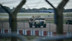 An armoured vehicle (C) patrols the interior at RAF Fairford base in Fairford, south-west England on September 28, 2026, a day after British counter-terrorism police were probing "a major" incident near the base. Armed officers detained a group of five men in the early hours after a call to emergency services about three "suspicious vehicles which appeared to be travelling towards the air base", London's Metropolitan Police said in a statement. (Photo by Ben STANSALL/AFP)
