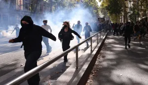 Protesters run from tear gas during student demonstrations in Lyon, eastern France on October 2, 2026. Since late September, students have staged protests outside schools over grievances ranging from timetables, class sizes and a shortage of teachers to overheated classrooms during this year's heatwaves. The protests started in the Ile-de-France region around Paris but have now spread to other cities nationwide. (Photo by Alex MARTIN/AFP)
