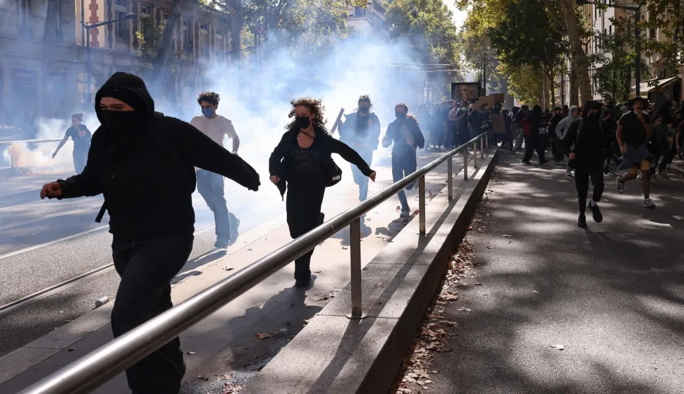 Protesters run from tear gas during student demonstrations in Lyon, eastern France on October 2, 2026. Since late September, students have staged protests outside schools over grievances ranging from timetables, class sizes and a shortage of teachers to overheated classrooms during this year's heatwaves. The protests started in the Ile-de-France region around Paris but have now spread to other cities nationwide. (Photo by Alex MARTIN/AFP)