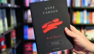 08 October 2026, Berlin: After the announcement of the Nobel Prize in Literature at the Dussmann Kulturkaufhaus, a man's hand is holding a book by the Canadian poet and essayist Anne Carson. Photo: Soeren Stache/dpa Photo: Soeren Stache/DPA