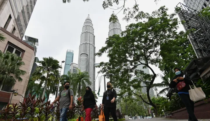 MALAYSIA-COVID-19-CASES (210713) -- KUALA LUMPUR, July 13, 2021 (Xinhua) -- People wearing face masks walk on a street near the Petronas Twin Towers in Kuala Lumpur, Malaysia, July 13, 2021. Malaysia reported 11,079 new COVID-19 infections in the highest daily spike since the outbreak, bringing the national total to 855,949, the Health Ministry said Tuesday. (Photo by Chong Voon Chung/Xinhua) Chong Voon Chung Photo: XINHUA/PIXSELL