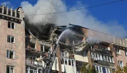 Firefighters work at a residential building damaged in a Russian drone strike in Kharkiv on October 12, 2026, amid the Russian invasion of Ukraine. (Photo by SERGEY BOBOK/AFP)