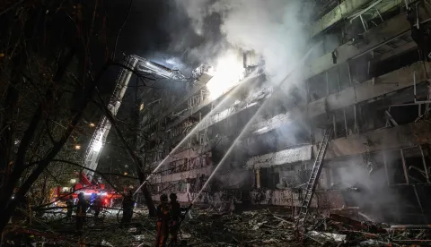 TOPSHOT - Ukrainian firefighters extinguish a blaze at the site of a Russian missile strike at an apartment building in Kyiv on October 14, 2026, amid the Russian invasion of Ukraine. (Photo by Genya SAVILOV/AFP)