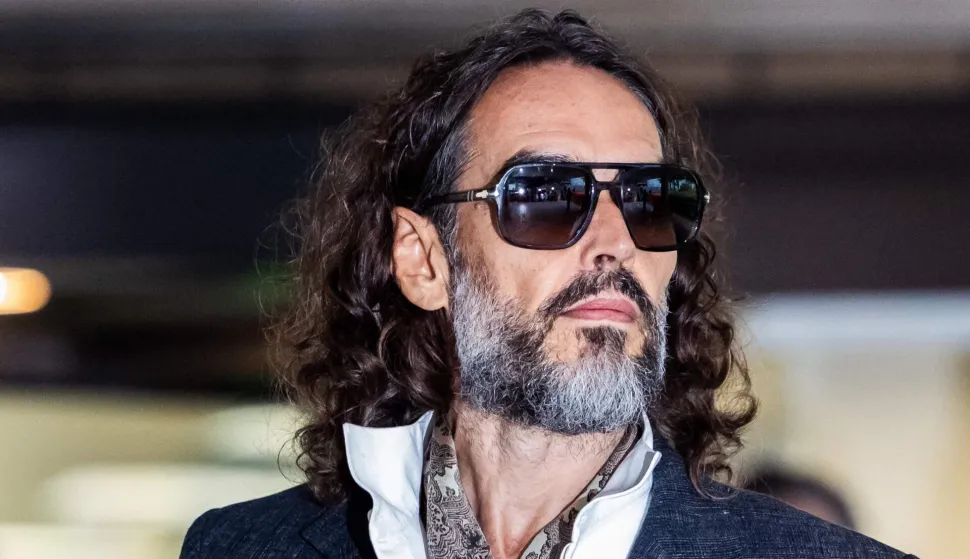 British comedian and actor Russell Brand leaves after jury selection finishes at the start of his trial at Southwark Crown Court in south London on October 12, 2026, after pleading not guilty to three charges of rape, indecent assault, and three counts of sexual assault. (Photo by Brook Mitchell/AFP)