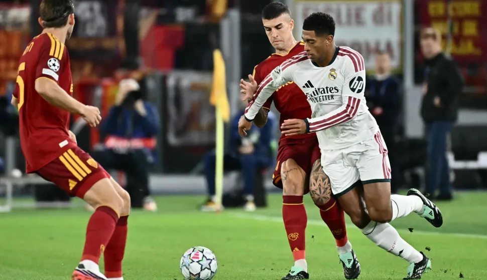 Real Madrid's English midfielder #05 Jude Bellingham fights for the ball with AS Roma's Italian defender #23 Gianluca Mancini during the UEFA Champions League - 1st round day 2 football match between AS Roma and Real Madrid at the Olympic Stadium in Rome on October 14, 2026. (Photo by Filippo MONTEFORTE/AFP)