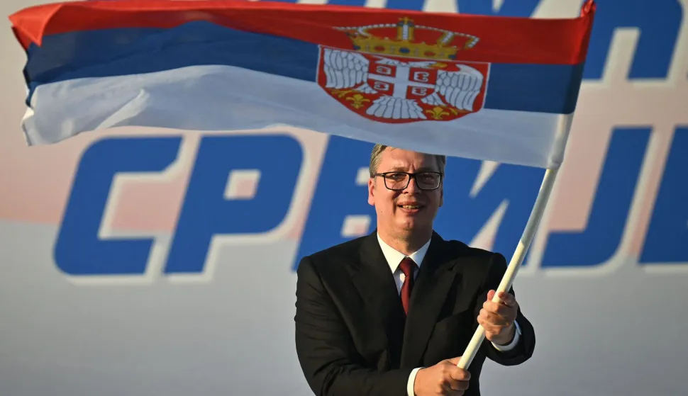 (FILES) Serbia's President Aleksandar Vucic waves a Serbian flag during a rally in Belgrade on June 27, 2026. Serbia?s President Aleksandar Vucic resigned on Sunday so he can run for prime minister in an October snap election called after nearly two years of student-led protests. "I am resigning as president," Vucic said from the presidential palace, where supporters chanted his name. "Tomorrow morning I will hand over my duties to the parliament speaker," he added. (Photo by OLIVER BUNIC/AFP)