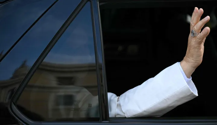 Pope Leo XIV waves as he arrives by car at the Vatican after being dissmissed from Rome's Gemelli University Hospital four days after doctors removed part of his right lung to extract a cancerous tumour, on October 17, 2026. (Photo by Andreas SOLARO/AFP)