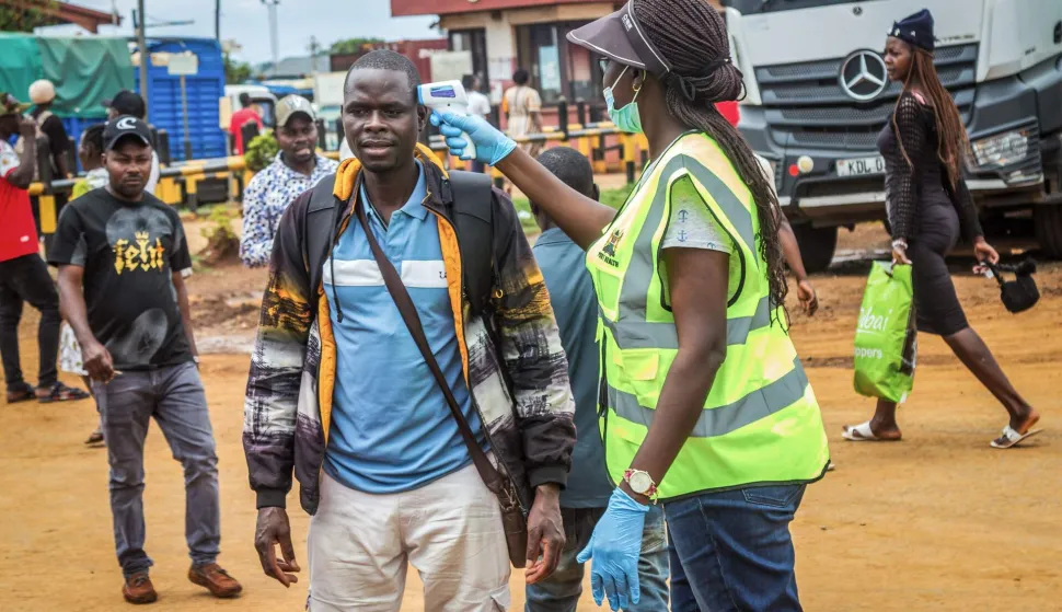 A Kenyan Ministry of Health official checks the temperature of a traveller at the Busia One Stop Border Post (OSBP) on the Kenya-Uganda border as health authorities step up Ebola screening measures, in Busia on October 12, 2026. Kenya reported its first-ever Ebola death, the health minister announced on October 6, 2026, after a Kenyan man who had been living in the Democratic Republic of Congo died after returning to the country.The DRC declared its 17th Ebola outbreak in May. The deadly disease has killed more than 15,000 people in Africa over the past 50 years. (Photo by Bright Emoja/AFP)