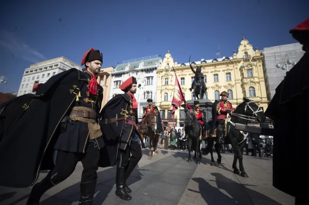 Zagreb, 18.10.2026 - Svečano obilježavanje Dana kravate pod pokroviteljstvom Hrvatskoga sabora i u organizaciji ustanove Academia Cravatica. Svečanost je započela s postrojavanjem i pregledom stroja i oružja i smjenom straže Kravat pukovnije. Jednako tako, ovom prigodom kao tradicionalna, igrana scena vezanja kravate na otvorenom po uzoru na dolazak hrvatskih konjanika na kraljevski dvor Luja XIV u Versaillesu koju su izveli glumački par Vedran Mlikota i Anica Kovačević. Nakon ove scene, obavijeno je vezanje kravate na spomeniku banu Jelačiću, te prema ustaljenoj praksi na spomenik predsjedniku dr. Franji Tuđmanu te drugim povijesnim spomenicima na trgovima u sredi&scaron;tu Zagreba. foto HINA/ Daniel KASAP/ dk 