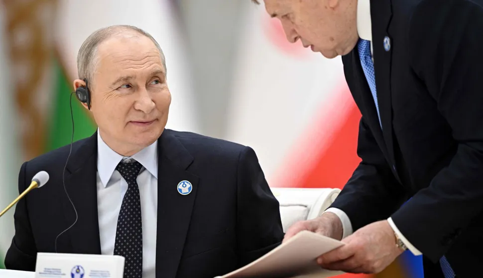 In this pool photograph distributed by the Russian state agency Sputnik, Russia's President Vladimir Putin interacts with Kremlin foreign policy aide Yuri Ushakov during a meeting of the Commonwealth of Independent States (CIS) Heads of State Council in Turkmenbashi on October 9, 2026. (Photo by Sergei BOBYLYOV/POOL/AFP)