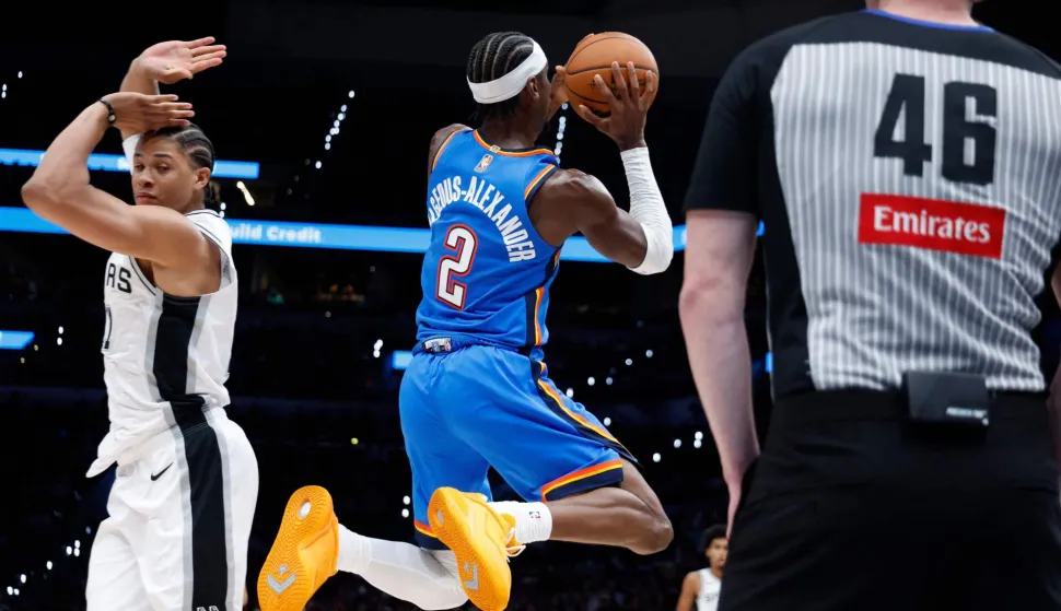 SAN ANTONIO, TX -OCTOBER 20: Shai Gilgeous-Alexander #2 of the Oklahoma City Thunder scores past Carter Bryant #11 of the San Antonio Spurs in the second half at Frost Bank Center on October 20, 2026 in San Antonio, Texas. NOTE TO USER: User expressly acknowledges and agrees that, by downloading and or using this photograph, User is consenting to terms and conditions of the Getty Images License Agreement. Ronald Cortes/Getty Images/AFP (Photo by Ronald Cortes/GETTY IMAGES NORTH AMERICA/Getty Images via AFP)
