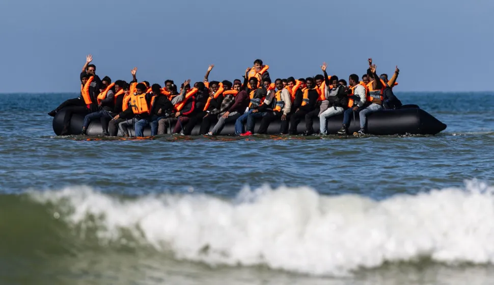 (FILES) Migrants try to board a smuggler's boat off the beach of Equihen-Plage, northern France, on September 23, 2026. Talks between France and Britain are under way on terms to end the "one-for-one" migration agreement concluded in the summer of 2025, the French Ministry of the Interior told AFP on September 30, 2026, confirming a report in Le Monde newspaper. (Photo by Sameer Al-DOUMY/AFP)