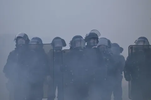 TOPSHOT - French gendarmes stand amidst tear gas during a demonstration in favor of purchasing power, the protection of public services, and fiscal and social justice, in Nantes, western France on October 24, 2026 as part of a nationwide call for mobilisation bringing together former members of the Yellow Vest movement, labor unions, high school and university students. Protests by high school students over learning conditions sparked a movement that has since spread nationwide, fuelled by broader anger over the rising cost of living. About 70,000 security personnel will be deployed on October 24, 2026, Interior Minister said at a news conference, warning that calls for violence and looting were circulating on social media. (Photo by Guillaume Saligot/AFP)