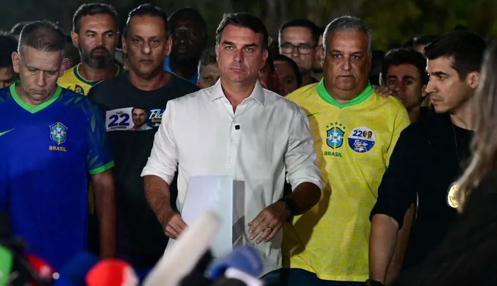 Brazil's right-wing senator and presidential candidate for the Liberal Party (PL) Flavio Bolsonaro (C) reacts after knowing the first results in the presidential runoff election, in Brasilia, on October 25, 2026. Brazil's President and re-election candidate for the Workers' Party (PT) Luiz Inacio Lula da Silva pulled off a dramatic comeback on October 25, 2026, as he clinched election victory against right-wing senator Flavio Bolsonaro, who trounced him in the first round. (Photo by Pablo PORCIUNCULA/AFP)