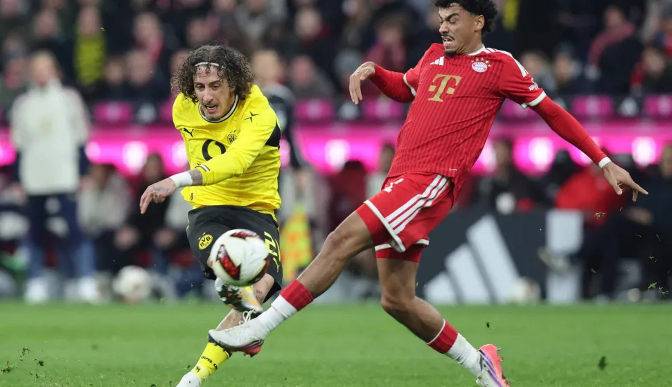 Dortmund's Portuguese forward #21 Fabio Silva (L) shoots past Bayern Munich's German defender #11 Nathaniel Brown during the German first division Bundesliga football match between FC Bayern Munich and BVB Borussia Dortmund in Munich, southern Germany, on October 31, 2026. (Photo by Alexandra BEIER/AFP)/DFL REGULATIONS PROHIBIT ANY USE OF PHOTOGRAPHS AS IMAGE SEQUENCES AND/OR QUASI-VIDEO